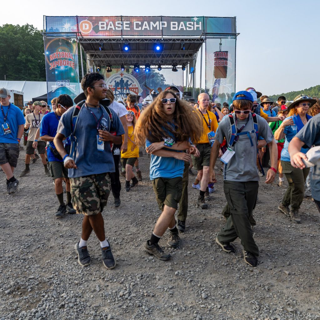 The DJ warms up the crowd and scouts are dancing at the Delta base camp Bash during the 2023 National Scout Jamboree at The Summit Bechtel Reserve in Mount Hope, West Virginia. (BSA Photo by Dan Glass)..**********Beginning of Shooting Data Section**********.20230725-19-21-00-20-DG     date - 7/25/23     time - 7:21:00 PM