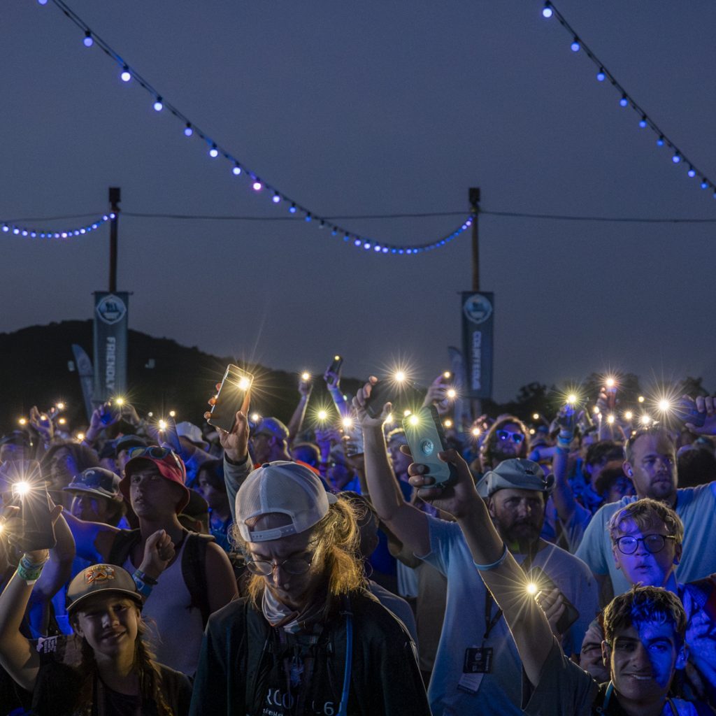 Scouts put on their phone flashlights on for the summit apex during the 2023 National Scout Jamboree at The Summit Bechtel Reserve in Mount Hope, West Virginia. (BSA Photo by Leo He)..**********Beginning of Shooting Data Section**********.20230726-21-05-17--LH     date - 7/26/23     time - 21:05:17
